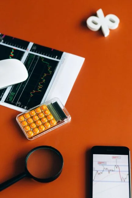 Flat lay of keyboard letter tiles spelling email on coral backdrop.