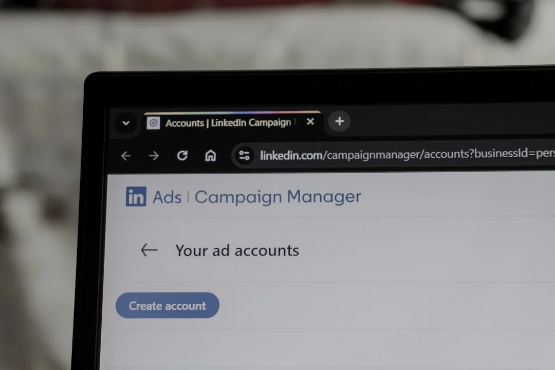 A close-up view of a smartphone screen displaying the email inbox, held by an adults hand.